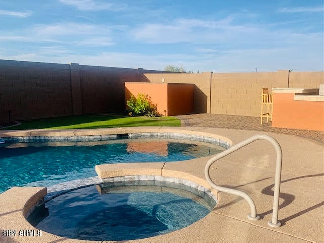 view of pool with an in ground hot tub