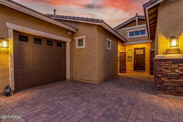 exterior entry at dusk with a garage