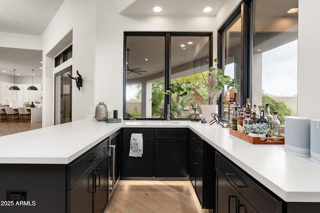 30600 N Pima Rd Unit 89, Scottsdale, AZ 85266 - kitchen featuring a peninsula, light wood-style flooring, light countertops, and dark cabinetry