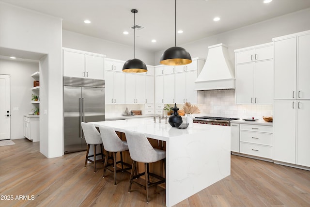 30600 N Pima Rd Unit 89, Scottsdale, AZ 85266 - kitchen with a kitchen breakfast bar, premium range hood, a kitchen island with sink, stainless steel appliances, and light wood finished floors
