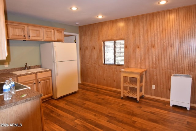 kitchen with dark wood-style flooring, freestanding refrigerator, light brown cabinetry, a sink, and recessed lighting