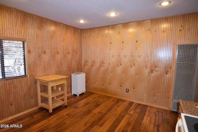 spare room with hardwood / wood-style flooring, recessed lighting, wooden walls, baseboards, and a heating unit