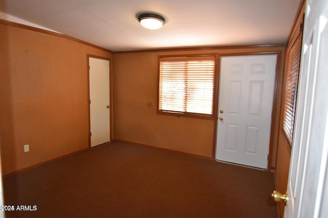 entrance foyer featuring carpet flooring and crown molding