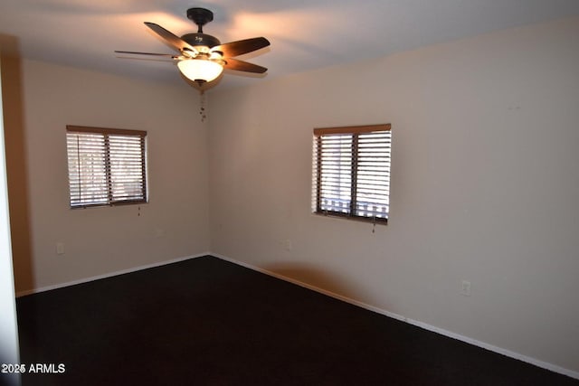 empty room with a ceiling fan and baseboards