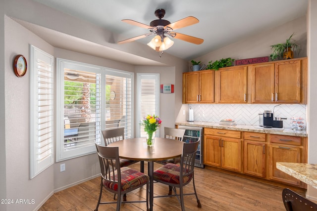 kitchen with wine cooler, light hardwood / wood-style flooring, tasteful backsplash, and lofted ceiling