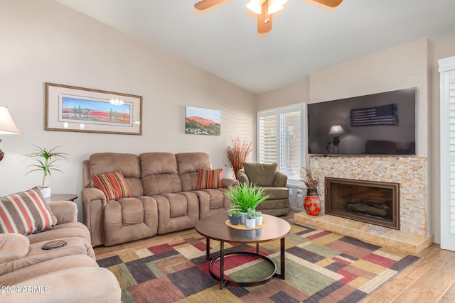 living room featuring lofted ceiling, ceiling fan, a tile fireplace, and hardwood / wood-style flooring