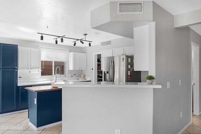 kitchen with blue cabinetry, light tile patterned floors, visible vents, and stainless steel refrigerator with ice dispenser