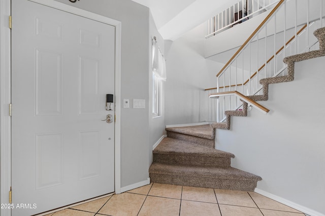 entrance foyer featuring tile patterned floors, stairway, and baseboards