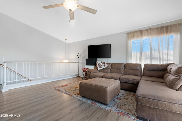 living area featuring wood finished floors, a ceiling fan, and vaulted ceiling