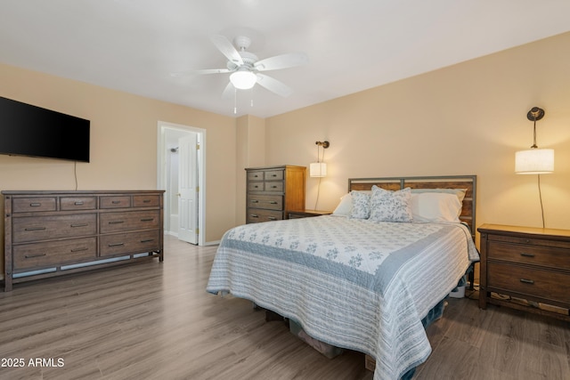 bedroom featuring ceiling fan, baseboards, and wood finished floors