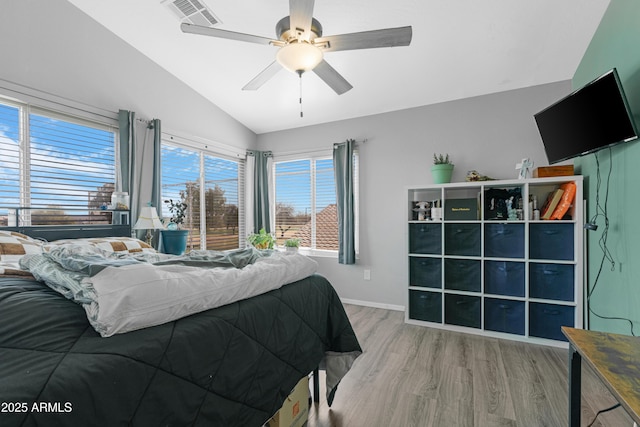 bedroom with visible vents, wood finished floors, baseboards, ceiling fan, and vaulted ceiling