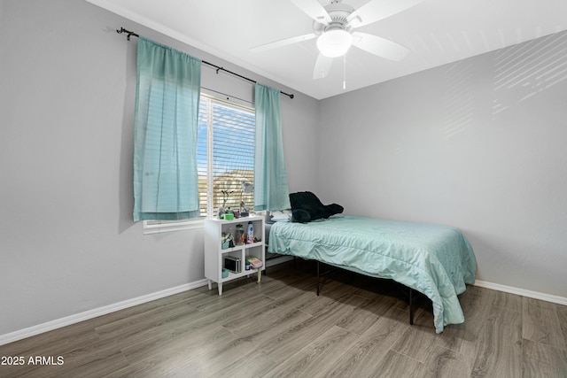 bedroom featuring ceiling fan, baseboards, and wood finished floors