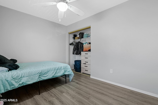 bedroom featuring wood finished floors, baseboards, a closet, and ceiling fan