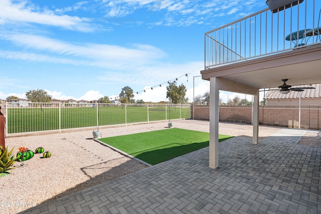 view of yard with a patio area, a fenced backyard, and ceiling fan