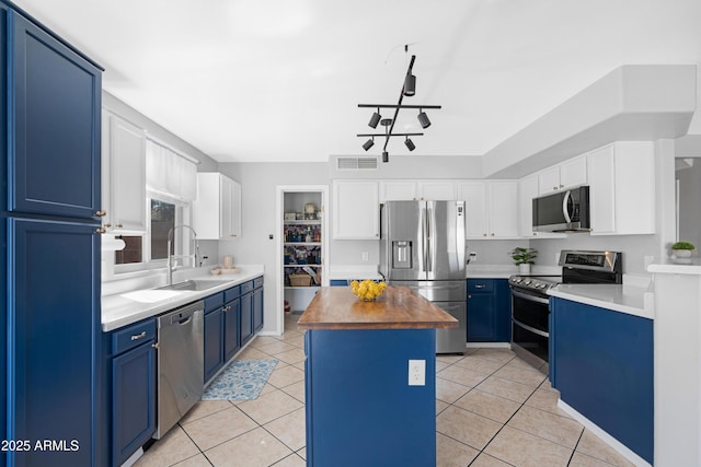 kitchen with visible vents, blue cabinetry, stainless steel appliances, and a sink