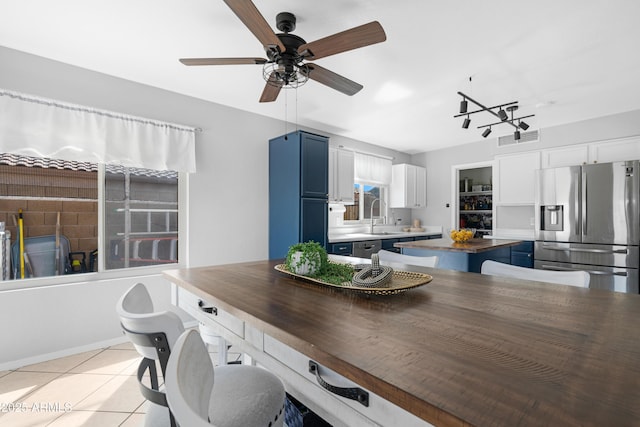 kitchen with visible vents, a kitchen island, a sink, appliances with stainless steel finishes, and blue cabinets