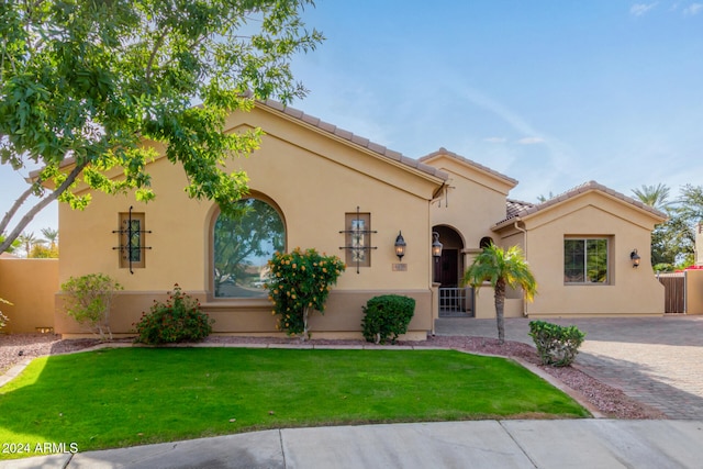 mediterranean / spanish-style home with a front lawn