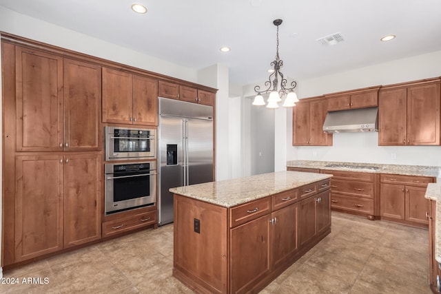 kitchen featuring decorative light fixtures, a kitchen island, light stone counters, stainless steel appliances, and a chandelier