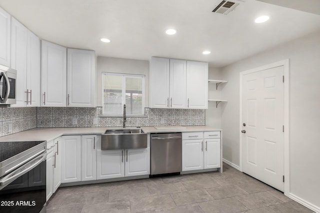 kitchen featuring visible vents, white cabinetry, stainless steel appliances, and a sink