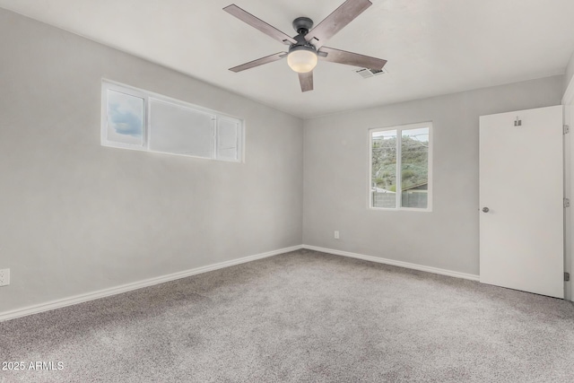 carpeted empty room featuring visible vents, baseboards, and ceiling fan