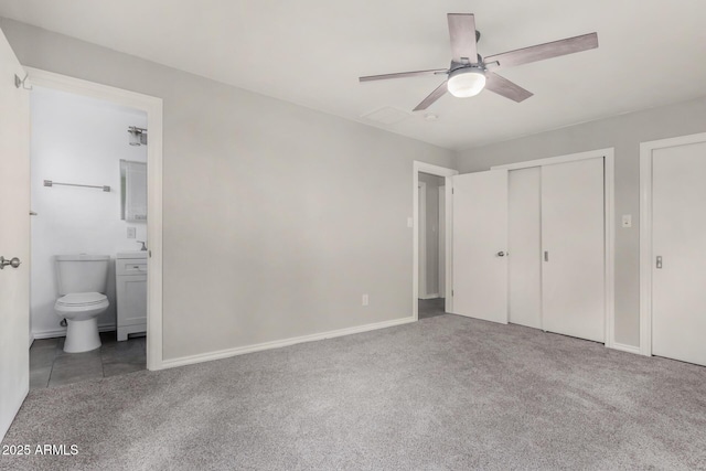 unfurnished bedroom with a ceiling fan, carpet, baseboards, and ensuite bathroom