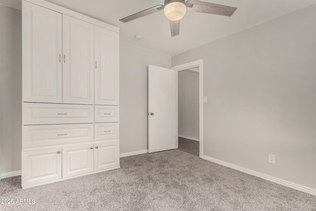 unfurnished bedroom with baseboards, carpet, and a ceiling fan