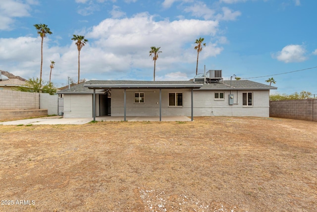 rear view of house featuring a patio area, a fenced backyard, central AC, and roof with shingles