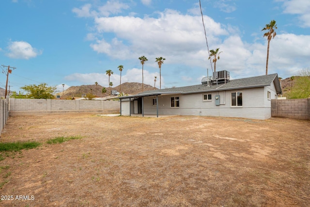 back of property featuring a mountain view, a fenced backyard, and roof with shingles