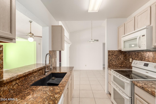 kitchen featuring light brown cabinets, sink, dark stone counters, lofted ceiling, and white appliances