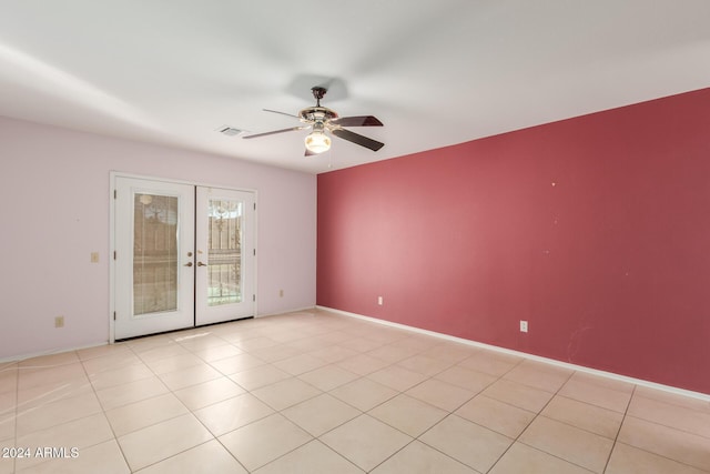 empty room with ceiling fan, french doors, and light tile patterned floors