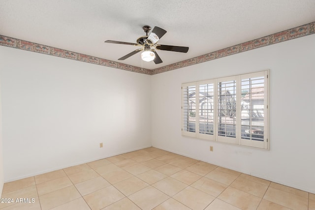 unfurnished room with ceiling fan, light tile patterned floors, and a textured ceiling