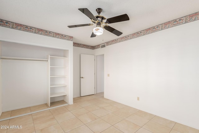 unfurnished bedroom featuring light tile patterned floors, a closet, and ceiling fan