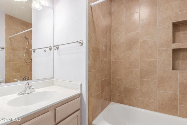 bathroom featuring tiled shower / bath combo and vanity