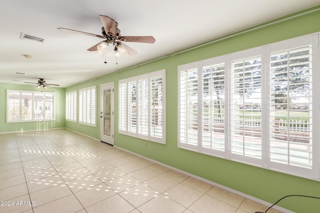 unfurnished sunroom featuring ceiling fan