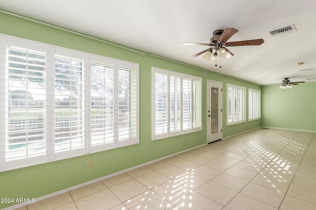 unfurnished sunroom with ceiling fan