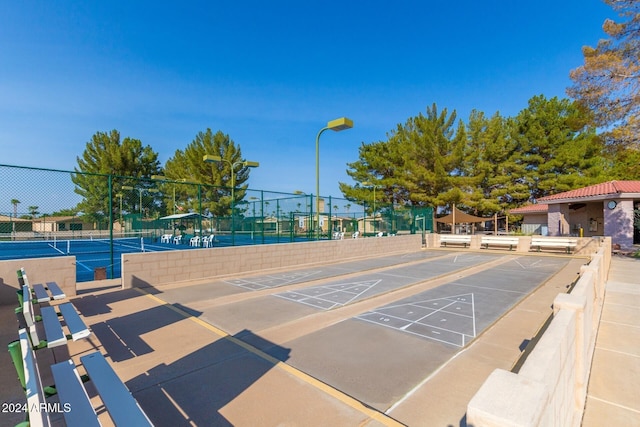 view of home's community featuring tennis court