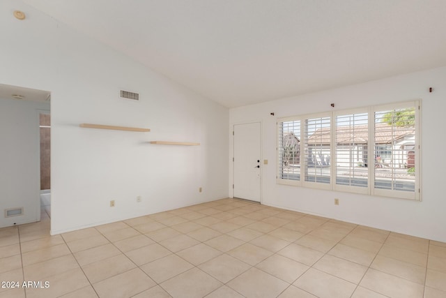 tiled spare room with lofted ceiling