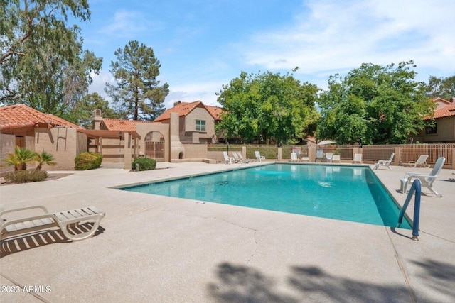community pool featuring a patio area and fence