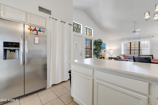 kitchen featuring white cabinets, light countertops, light tile patterned floors, stainless steel refrigerator with ice dispenser, and visible vents