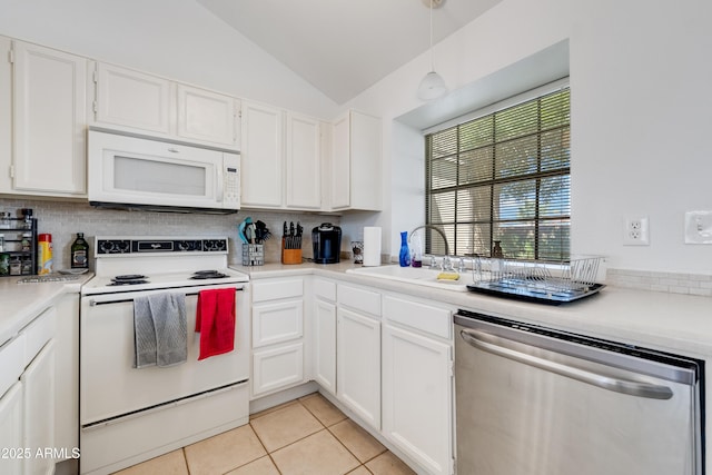 kitchen with a sink, white appliances, white cabinetry, decorative backsplash, and vaulted ceiling