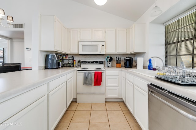 kitchen featuring a sink, white appliances, light countertops, lofted ceiling, and visible vents