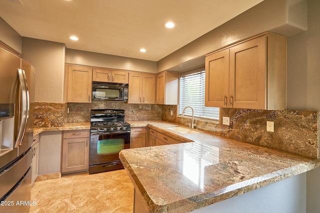 kitchen with black appliances, tasteful backsplash, a peninsula, and a sink