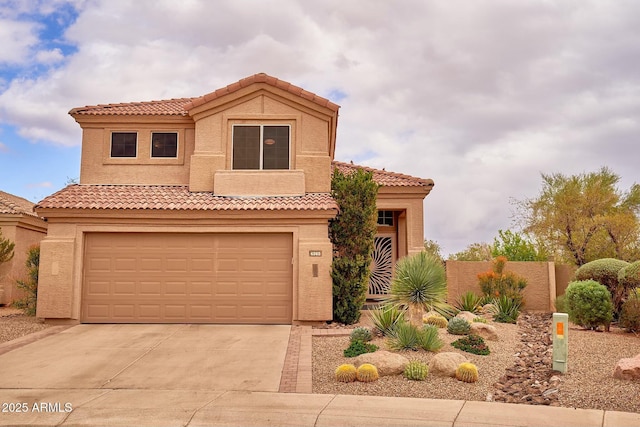 mediterranean / spanish-style home with concrete driveway, an attached garage, a tiled roof, and stucco siding