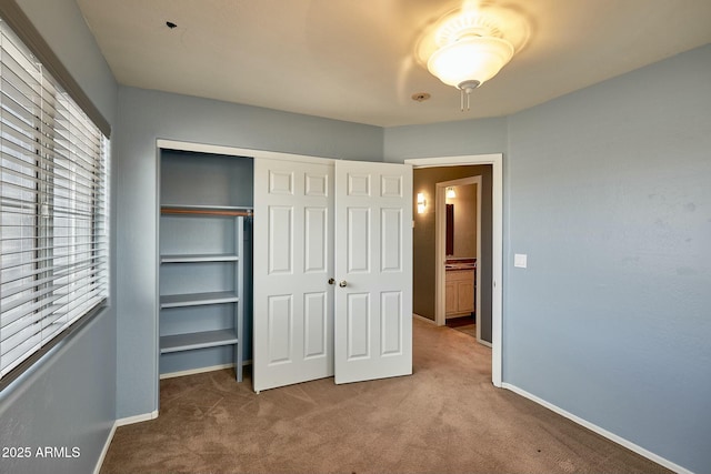 unfurnished bedroom featuring a closet, carpet flooring, and baseboards