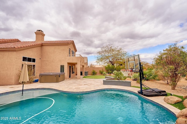 pool featuring a patio, a hot tub, and fence