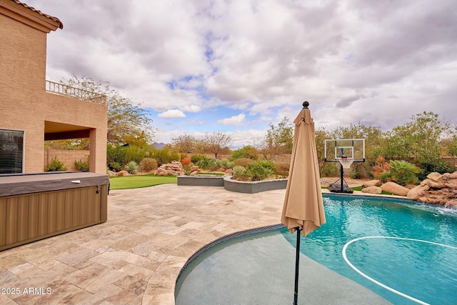 pool with a hot tub and a patio