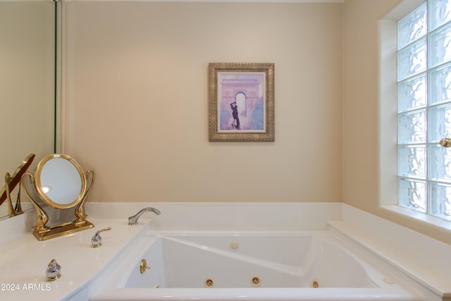 bathroom featuring a tub with jets and a wealth of natural light