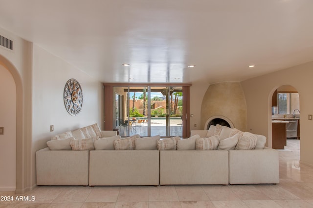 living area featuring arched walkways, visible vents, and recessed lighting