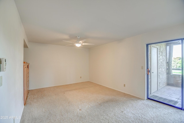 unfurnished room with a ceiling fan and carpet