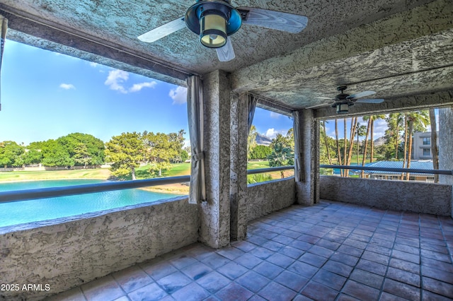 unfurnished sunroom featuring ceiling fan